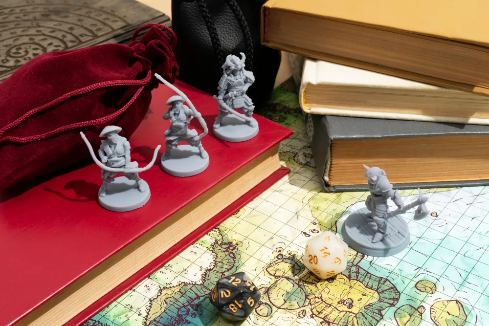 Miniatúry postáv pre stolné hry, hracia kocka D20 a kniha položené na hracej mape sveta pre tabletop RPG.